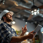 A photograph of a lighting contractor examining a stylish ceiling fan in a well-lit showroom