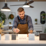 A photograph of a skilled lighting contractor examining various ceiling fan switches in a well-lit
