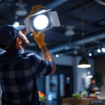 A photograph of a lighting contractor installing led indoor flood lights in a modern commercial space