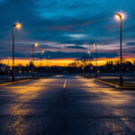 A photograph of a well-lit parking lot at dusk