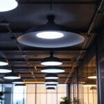 A photograph of a well-lit office space featuring modern ceiling lights