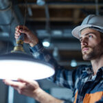 A photograph of a lighting contractor installing wafer led lights in a commercial setting