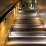 A photograph of a beautifully illuminated staircase featuring a variety of lighting options