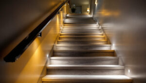 A photograph of a beautifully illuminated staircase featuring a variety of lighting options