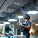 A photograph of a lighting contractor expertly installing cam lights in a residential or commercial space
