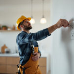 A photograph of a skilled electrician installing modern electrical receptacles in a well-lit residential space