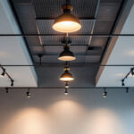 A photograph of a well-lit room featuring stylish ceiling lights installed in a drop ceiling