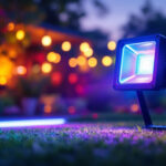 A photograph of a vibrant outdoor scene showcasing a multi-color flood light illuminating a garden or patio area at dusk