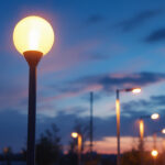 A photograph of a well-lit street scene featuring modern street pole lights
