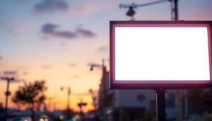 A photograph of a brightly illuminated outdoor led sign in a commercial setting at dusk