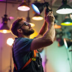 A photograph of a lighting contractor meticulously adjusting various light fixtures in a well-lit space