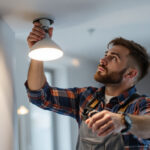 A photograph of a lighting contractor efficiently installing led pot lights in a modern home setting