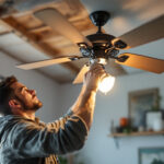 A photograph of a lighting contractor installing a ceiling fan switch in a residential setting