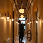A photograph of a well-lit hallway featuring stylish lamps and lighting fixtures