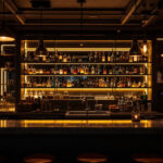 A photograph of a stylishly illuminated bar scene showcasing various lighting fixtures and their effects on the ambiance