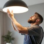 A photograph of a lighting contractor expertly installing or adjusting a modern lighting fixture in a stylish