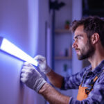 A photograph of a lighting contractor installing a 4ft led strip light in a modern indoor setting