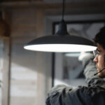 A photograph of a skilled lighting contractor installing a sleek 4 ft light fixture in a modern interior space