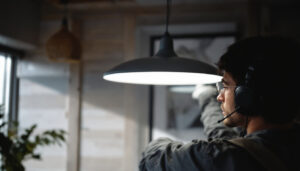 A photograph of a skilled lighting contractor installing a sleek 4 ft light fixture in a modern interior space