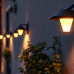 A photograph of a well-lit outdoor space showcasing various styles of solar-powered wall-mounted lights installed on a home or garden wall