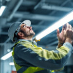 A photograph of a lighting contractor installing a 4ft t8 led lamp in a commercial setting