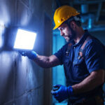 A photograph of a lighting contractor using a bright