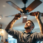 A photograph of a skilled lighting contractor assembling or installing various parts of a ceiling fan