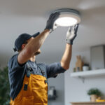 A photograph of a skilled lighting contractor expertly replacing a recessed light fixture in a modern home