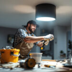 A photograph of a lighting contractor installing a pot light conversion kit in a modern home setting