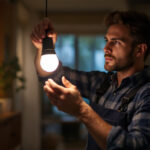 A photograph of a lighting contractor expertly installing an mr16 light bulb in a stylish residential setting