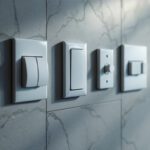 A photograph of a close-up shot of various types of light switches installed in a modern home setting