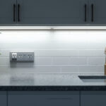 A photograph of a beautifully lit kitchen showcasing under cabinet lighting illuminating the countertop
