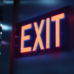 A photograph of a well-lit emergency exit sign in a commercial building