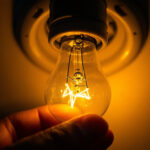 A photograph of a close-up of a flickering light bulb in a socket