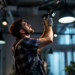 A photograph of a lighting contractor skillfully installing or adjusting modern lighting fixtures in a well-lit space