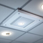 A photograph of a close-up shot of a junction box cover plate installed in a well-lit ceiling