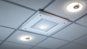 A photograph of a close-up shot of a junction box cover plate installed in a well-lit ceiling