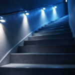 A photograph of a well-lit staircase featuring stylish stair lights