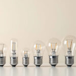 A photograph of a close-up of various standard light bulb bases arranged on a clean