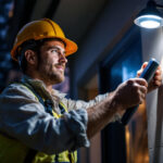 A photograph of a lighting contractor installing solar cell lights in a residential or commercial setting