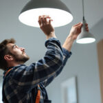 A photograph of a lighting contractor expertly installing a modern lighting fixture in a well-lit space