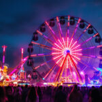 A photograph of a vibrant carnival scene at dusk