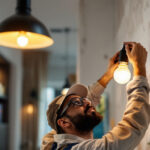 A photograph of a skilled lighting contractor expertly installing a stylish light fixture in a modern interior setting