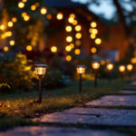 A photograph of a beautifully illuminated outdoor space featuring a variety of small solar lights