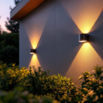 A photograph of a beautifully illuminated outdoor space featuring solar-powered wall lights installed on a stylish exterior wall