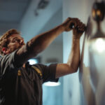 A photograph of a lighting contractor actively installing or adjusting stylish