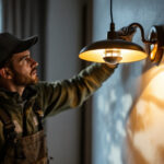 A photograph of a lighting contractor skillfully installing an elegant light fixture in a beautifully designed space