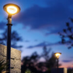 A photograph of a beautifully illuminated outdoor space featuring a sleek spotlight fixture in use