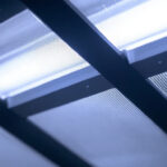 A photograph of a close-up of a fluorescent light fixture with a visible diffuser