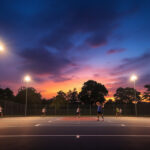 A photograph of a well-lit sport court at dusk